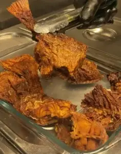 A close-up of a crispy fried fish, perfectly golden and seasoned, served as a traditional Caribbean dish.