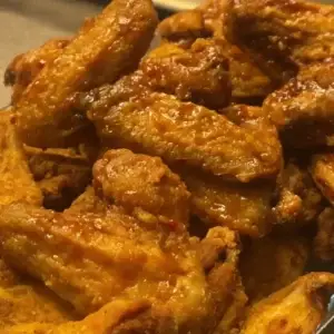 A plate of crispy fried chicken wings, golden brown and seasoned to perfection, served hot and ready to enjoy.