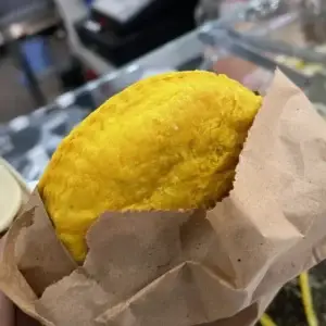 A traditional Caribbean beef patty, golden and flaky on the outside, filled with a spiced beef filling, fresh from the oven.